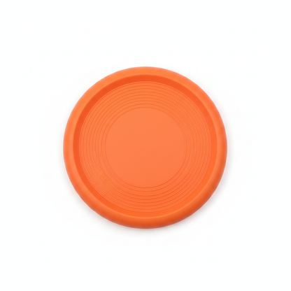 Orange rubber dog frisbee flat lay top-down view on white background