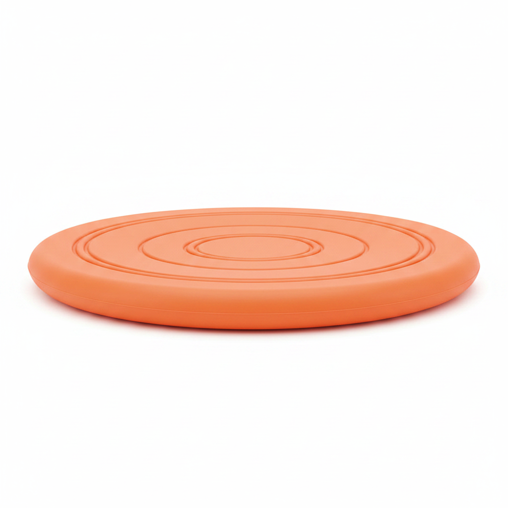 Side profile view of orange rubber dog frisbee showing disc thickness