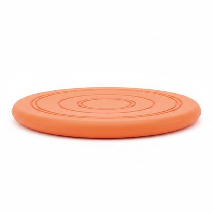 Side profile view of orange rubber dog frisbee showing disc thickness