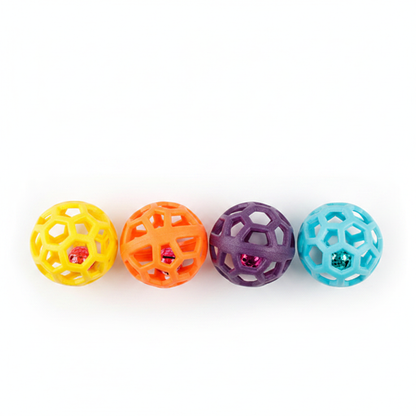 Four colorful hollow rubber pet jingle balls flat lay on white background